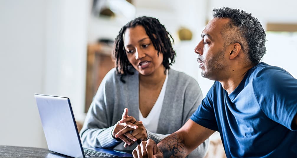 Couple researching on laptop